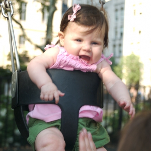 Sara giggles as she swings