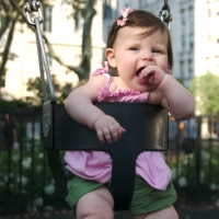 Sara giggles as she swings